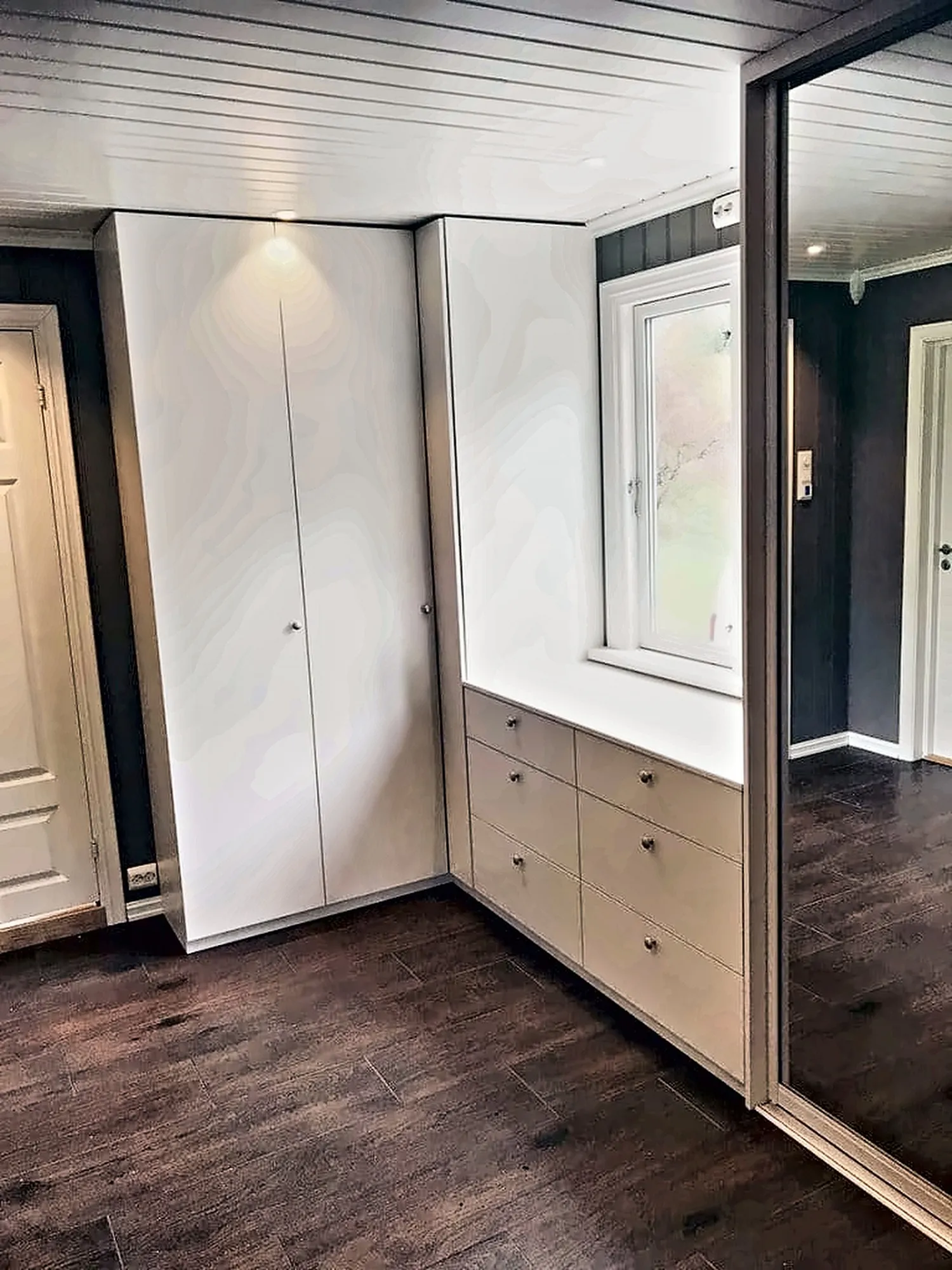 Hjørnegarderobe i gang med speilskyvedør og kommode i hvitt