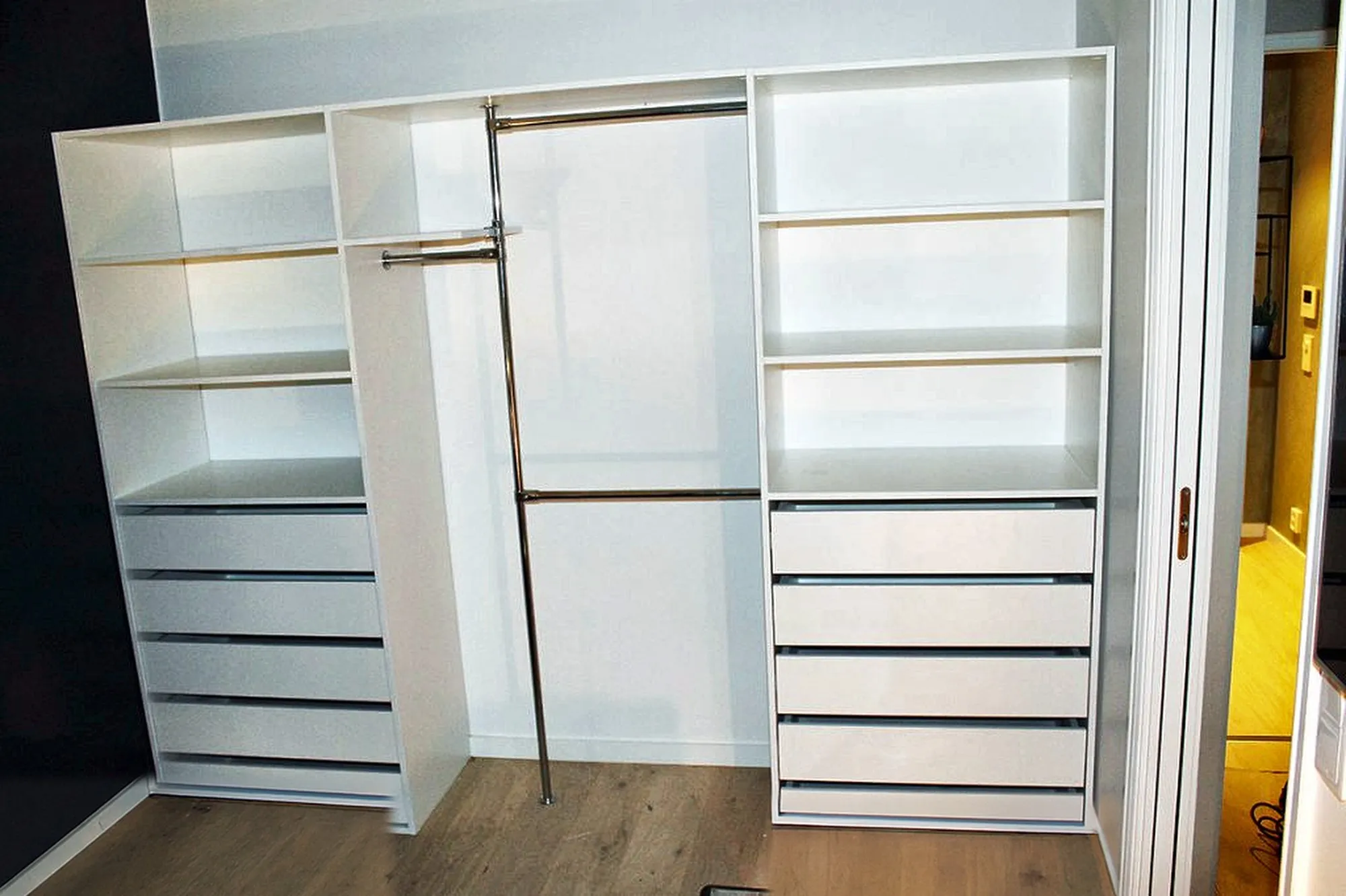 Garderobe med hvite glassfronter, innvendige hyller og skuffer