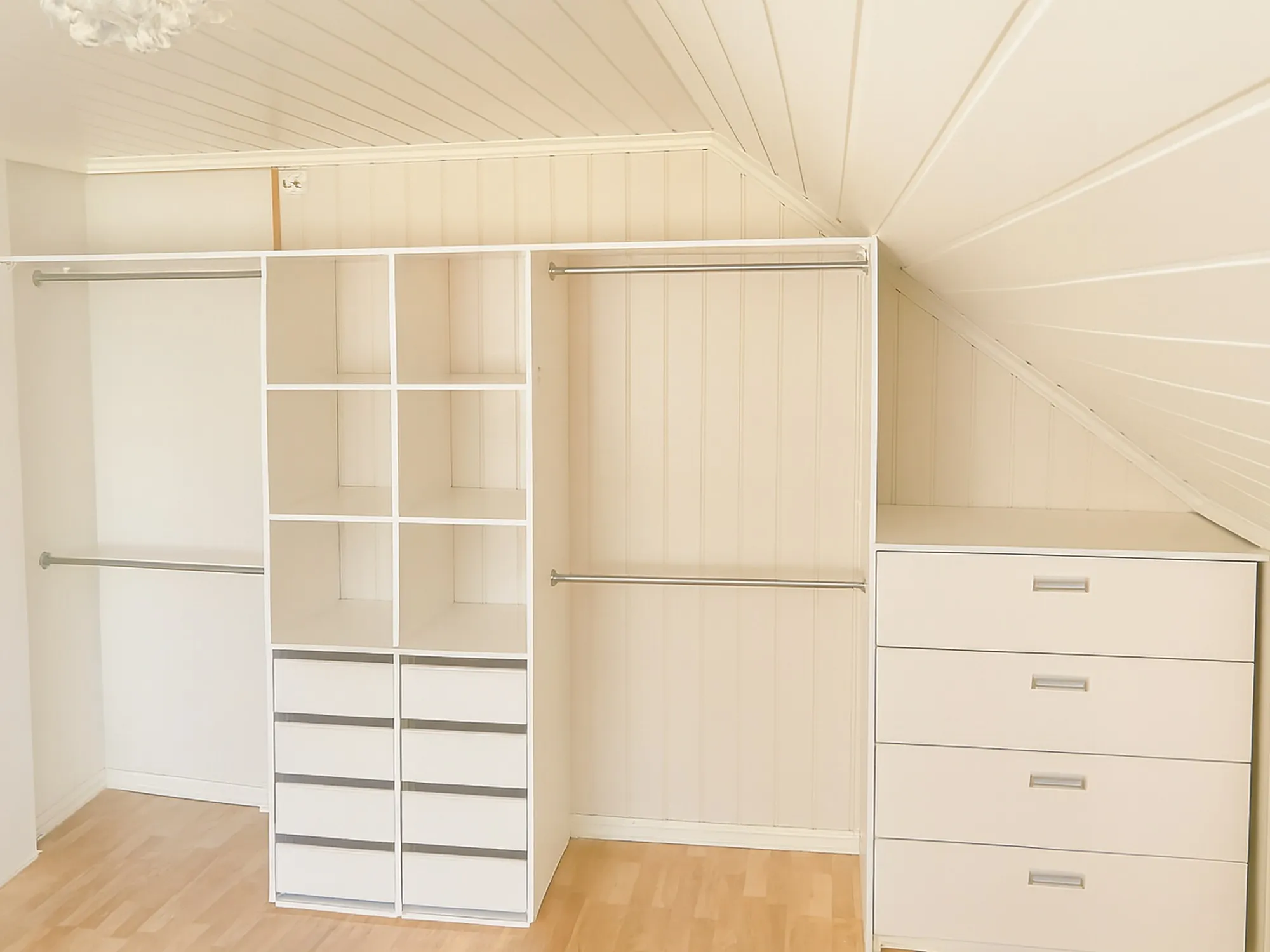 Garderobe med skyvedører bygget inn under skråtak langs hele veggen