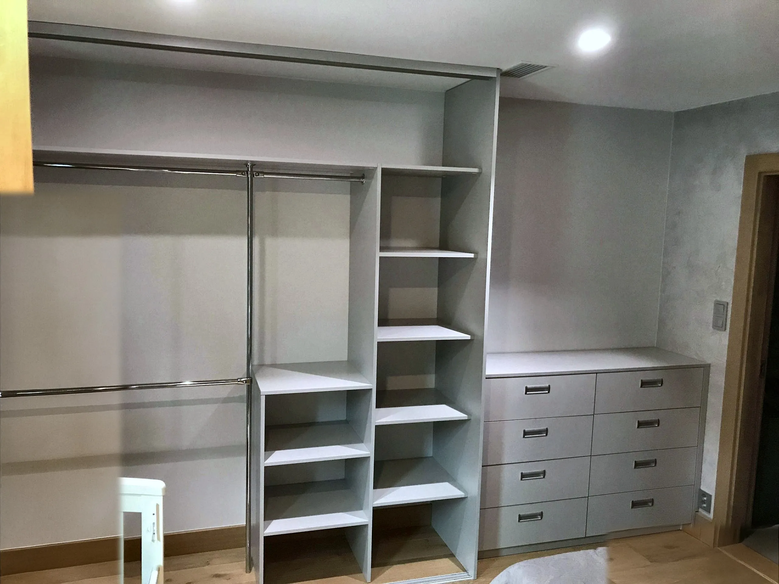 Walk-in-garderobe med hyller, kommode med seks skuffer og åpen hengeseksjon